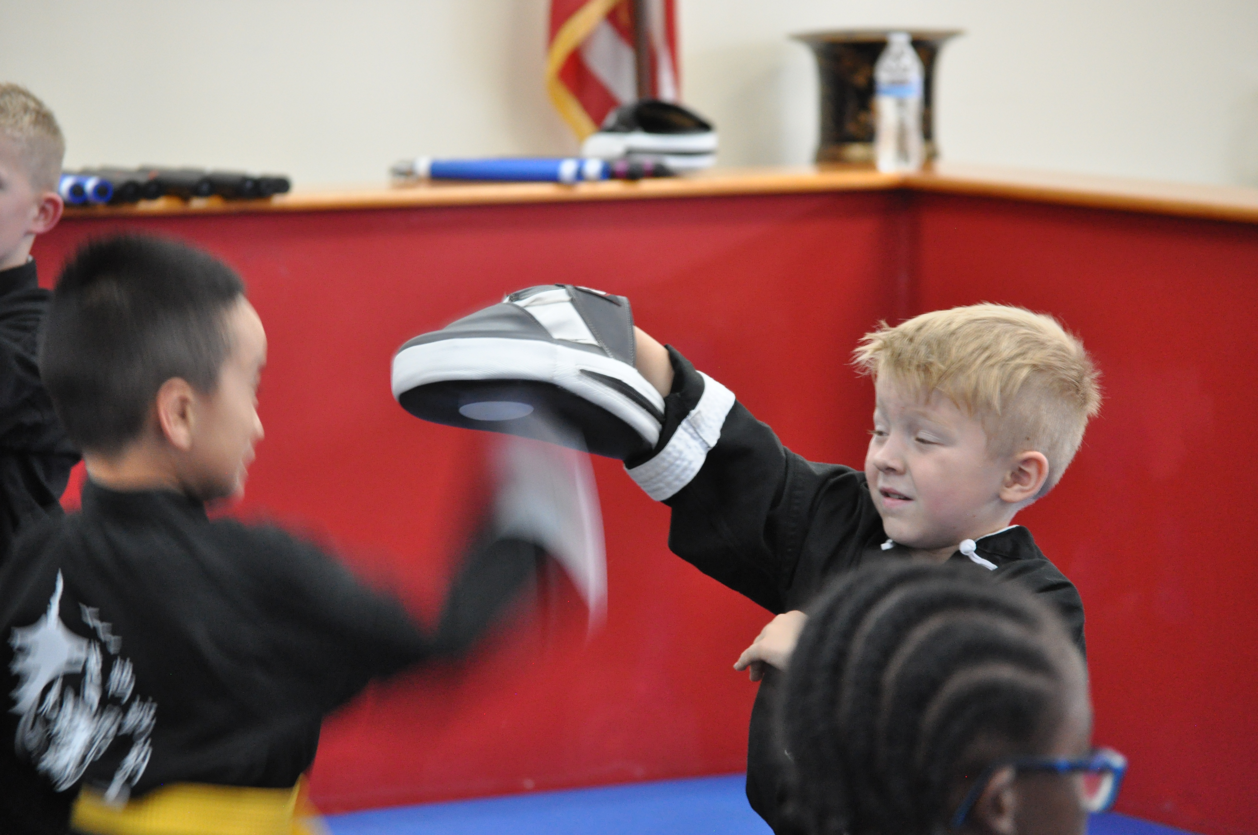 confidence building martial arts program kids karate hitting pads img