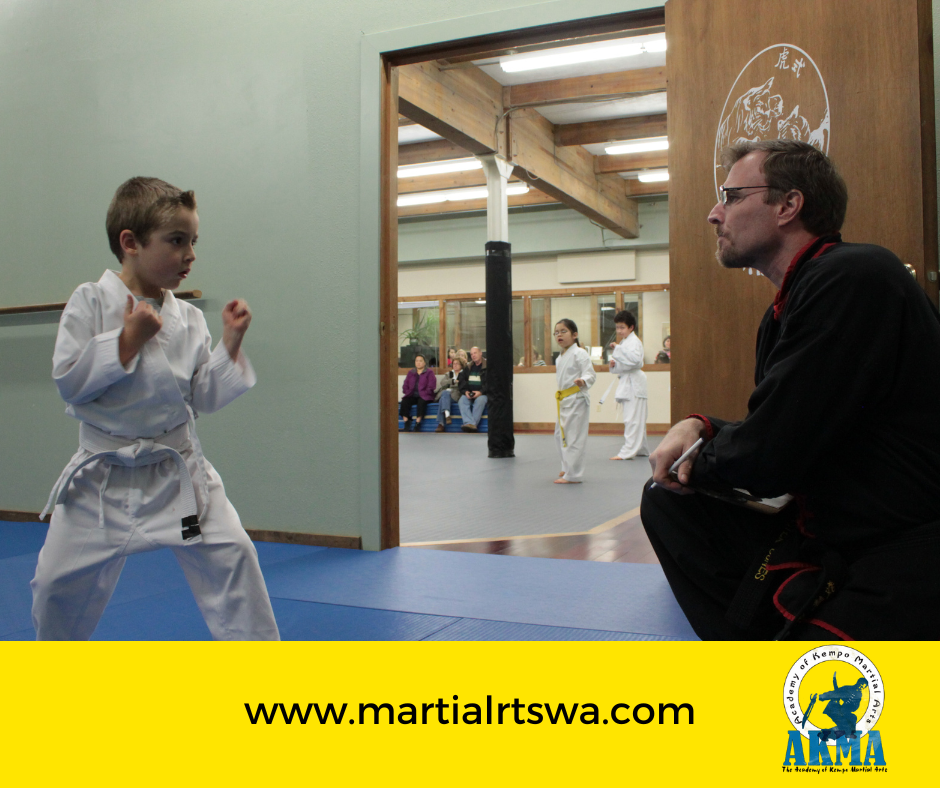 Instructor guiding student through challenging martial arts drill at Academy of Kempo Martial Arts