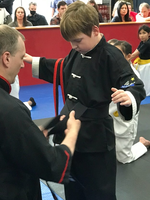 young student getting their black belt at the academy of kempo martial arts image